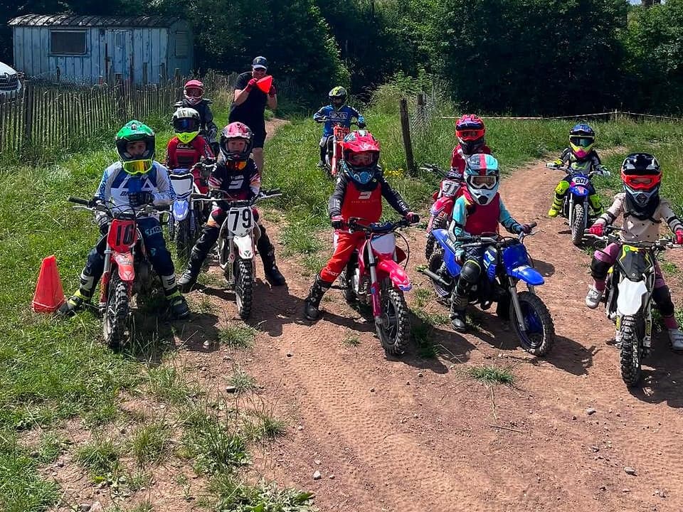Une dizaine d'enfants casqués sur leurs mini motos, prêts à partir derrière le moniteur